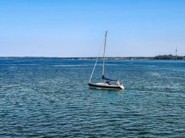 Estonya 'nın Tallinn kenti yakınlarındaki Baltık Denizi' nin mavi sularında bir yelkenli seyahat eder. İkonik Tallinn TV Kulesi açık bir gökyüzünün altında görülebilir. Yüksek kalite fotoğraf