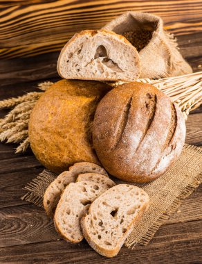 Ahşap masa arkasında pişmiş ekmek çeşitleri