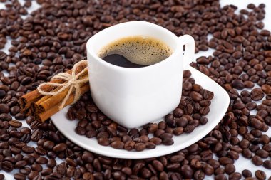 Beyaz arka planda kahve fincanı ve fasulye..