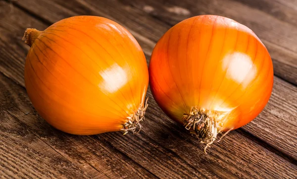 Kleurrijke uien op rustieke houten achtergrond — Stockfoto