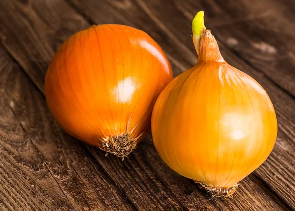 Kleurrijke uien op rustieke houten achtergrond — Stockfoto