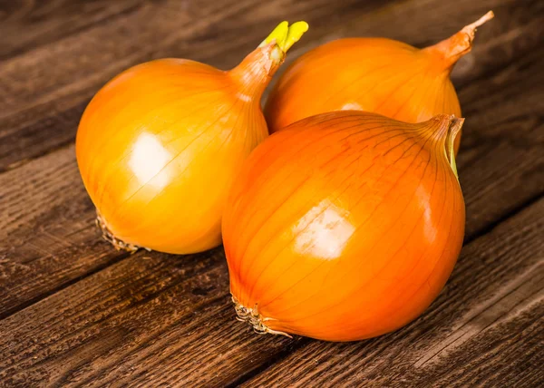 Kleurrijke uien op rustieke houten achtergrond — Stockfoto