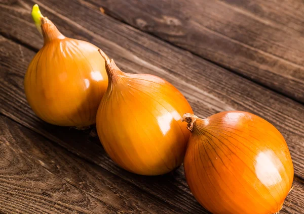 Kleurrijke uien op rustieke houten achtergrond — Stockfoto