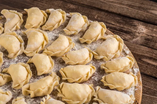 Pierogy, Masa, ahşap bir masaya yapma kesme heykeltraşlık. — Stok fotoğraf