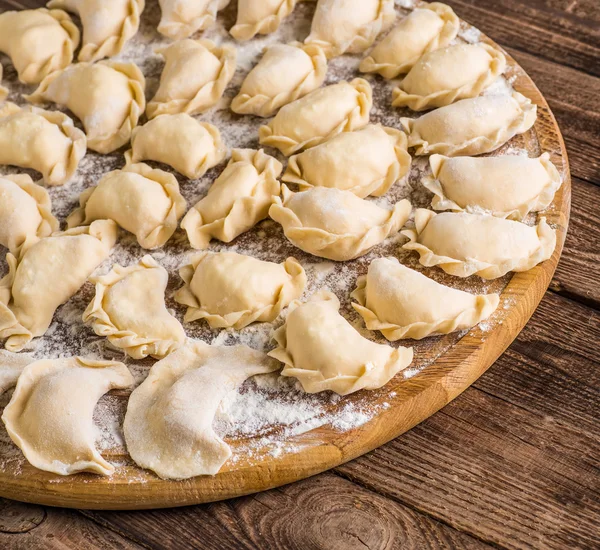 Pierogy, Masa, ahşap bir masaya yapma kesme heykeltraşlık. — Stok fotoğraf