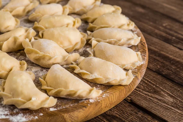 Pierogy, Masa, ahşap bir masaya yapma kesme heykeltraşlık. — Stok fotoğraf