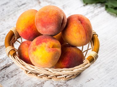 olgun şeftali ve yapraklar masada