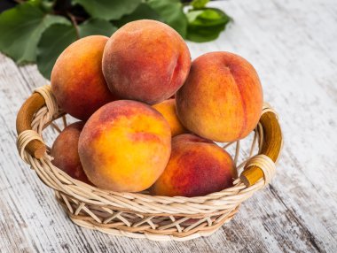 olgun şeftali ve yapraklar masada