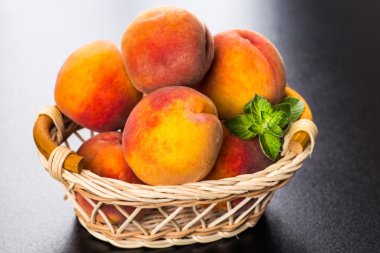 olgun şeftali ve yapraklar masada