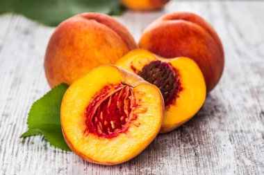 olgun şeftali ve yapraklar masada