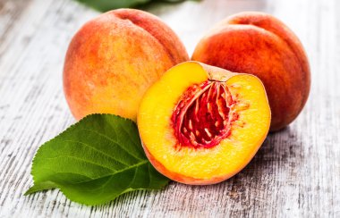 olgun şeftali ve yapraklar masada