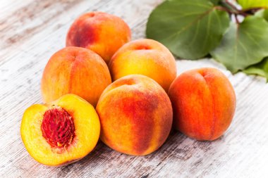 olgun şeftali ve yapraklar masada