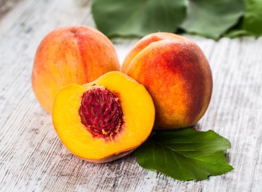 olgun şeftali ve yapraklar masada