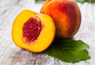 olgun şeftali ve yapraklar masada