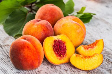 olgun şeftali ve yapraklar masada