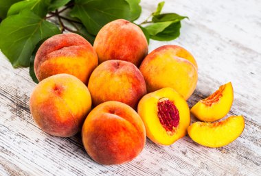 olgun şeftali ve yapraklar masada