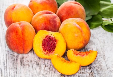 olgun şeftali ve yapraklar masada