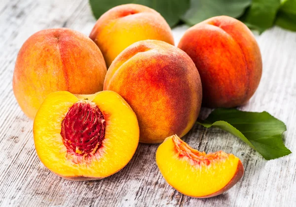 olgun şeftali ve yapraklar masada