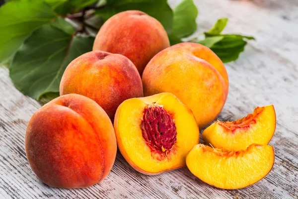 olgun şeftali ve yapraklar masada