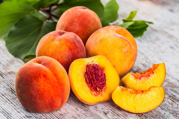 спелые персики и листья на столе