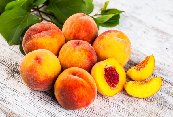 olgun şeftali ve yapraklar masada