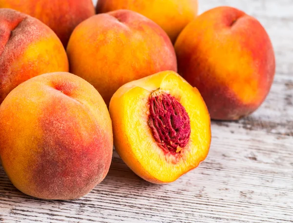 olgun şeftali ve yapraklar masada