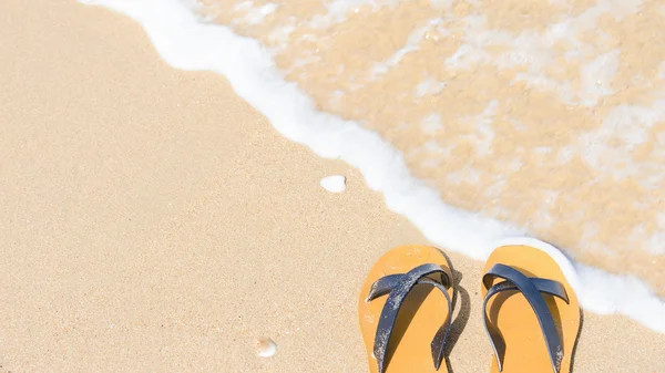 Tropical vacation concept - sandal on a sandy beach — Stock Photo, Image