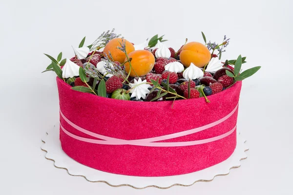 Красивый фруктовый торт с розовым печеньем вокруг него — стоковое фото