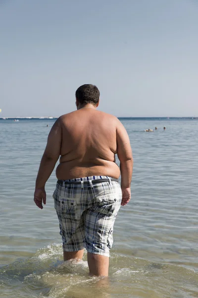 Надмірна вага людини, яка входить в море Стокове Фото