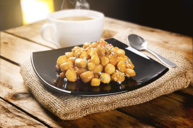 struffoli ve bitkisel çay ile ahşap masa
