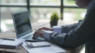 İş adamlarının yakın çekimleri masadaki muhasebe istatistiklerinin sohbetlerini gösteren ayrıntıları ve yazıları kontrol ediyor.