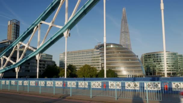 LONDRES / REINO UNIDO 6 DE SETEMBRO DE 2015 - Pan de um barco do rio Tâmisa até Tower Bridge e o World Trade Centre. Tomado em uma manhã clara de outono com luz dourada e em 4K — Vídeo de Stock