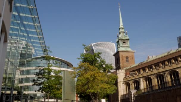 LONDON/UNITED KINGDOM 6TH SEPTEMBER 2015 - Tilt down the spire of the church of All Hallows by The Tower with the skyline of The City of London behind. Taken on a sunny autumn morning — Stock Video