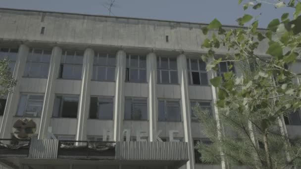 Tilt Bawah Terlantar Blok Kantor Pripyat Dibingkai Oleh Pohon Chernobyl — Stok Video