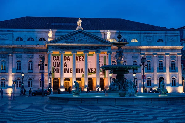 ポルトガルのリスボンのRossia Squareにある国立劇場のブロンズ噴水と照明付きのファサード 夜の間に — ストック写真
