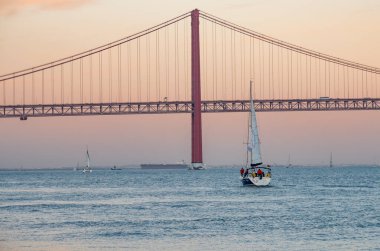 25 Nisan Köprüsü ve yatı denize açılmış Tagus Nehri. Arka planda İsa 'nın mabedi var.