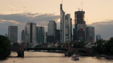 Bulutlar şehrin üzerinden geçerken Frankfurt ufuk çizgisinde günbatımının hızlanması. Bir yaz akşamı, iş çıkış saatinde çekilmiş.