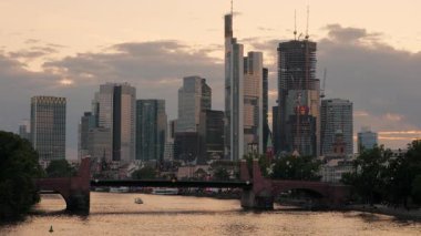 Frankfurt siluetinin ortasında bulutlar şehrin üzerinden geçerken. Bir yaz akşamı, iş çıkış saatinde çekilmiş.