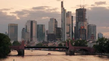 Gün batımında Ignatz Bubis Köprüsü 'nden çekilen Frankfurt siluetinin geniş bir görüntüsü. Şehir ışıkları yanmaya başladı.