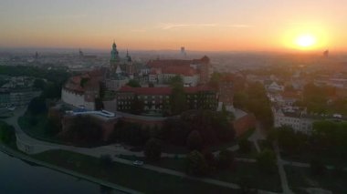 İnsansız hava aracı, muhteşem bir yaz gündoğumu sırasında Polonya 'nın Krakow kentindeki Wawel Kalesi' nin etrafında dönüyor. Arka planda eski kasaba var.