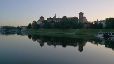 Drone Vistula Nehri 'nden Polonya' nın Krakow kentindeki Wawel Kalesi 'ne doğru yükseliyor. Çarpıcı bir yaz gündoğumu sırasında çekilmiş.