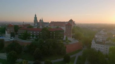 İnsansız hava aracı, muhteşem bir yaz gündoğumu sırasında Polonya 'nın Krakow kentindeki Wawel Kalesi' nin etrafında dönüyor. Arka planda eski kasaba var.