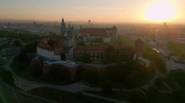 Muhteşem bir yaz gündoğumu sırasında Polonya 'nın Krakow kentindeki Wawel Kalesi' nin yanında insansız hava aracı yükseliyor. Arka planda eski kasaba var.