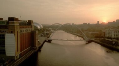 NEWCASTLE / UK 6 Eylül 2023: İHA Baltık Merkezi 'nden Newcastle' a doğru Tyne Nehri 'nin kenarından uçuyor. Milenyum Köprüsü ön planda. Akşam karanlığında çekilen