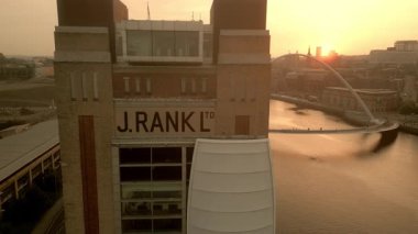 NEWCASTLE / UK 6. EPTEMBER 2023: İHA bulutlu bir yaz günbatımında Millennium Köprüsü, Newcastle ve River Tyne 'ı ortaya çıkarmak için Baltık Merkezi Kapılarından yan uçuyor