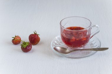 Bir bardak çilek jus, bir kırmızı gül ve iki çilek