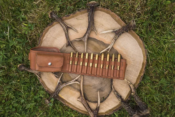 Hunting belt with cartridges and a lot of antlers — Stock Photo, Image