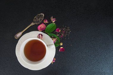 Çay saati konsepti. Beyaz fincan çay, küçük kaşık ve kuru çay.