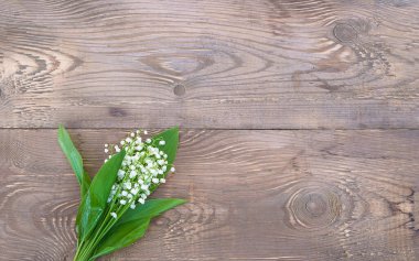 Mutlu bayramlar tebrik kartı. Kırsal ahşap arka planda vadi zambakları. Metin için boşluk, düz uzanma