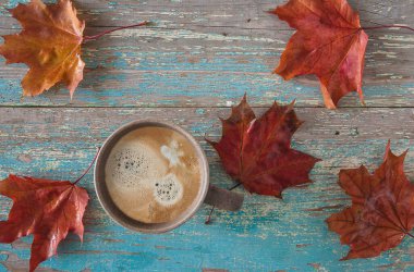 Sonbahar kahve molası, bir fincan kahve ve akçaağaç yaprağı.